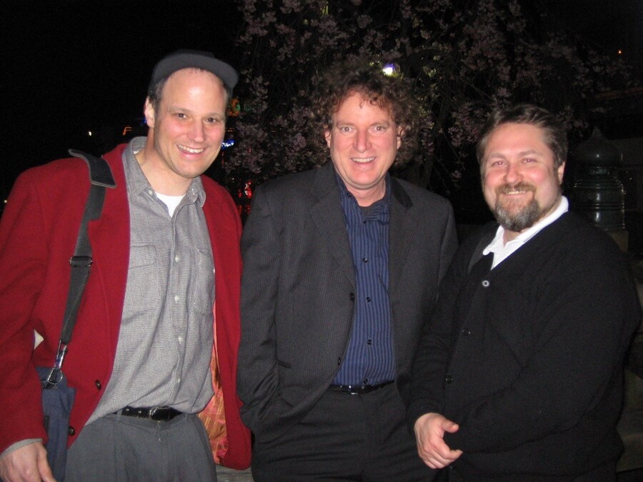 Michael Cohen, Durand R. Begault, and Bill Martens standing together outdoors at night beneath cherry blossoms.